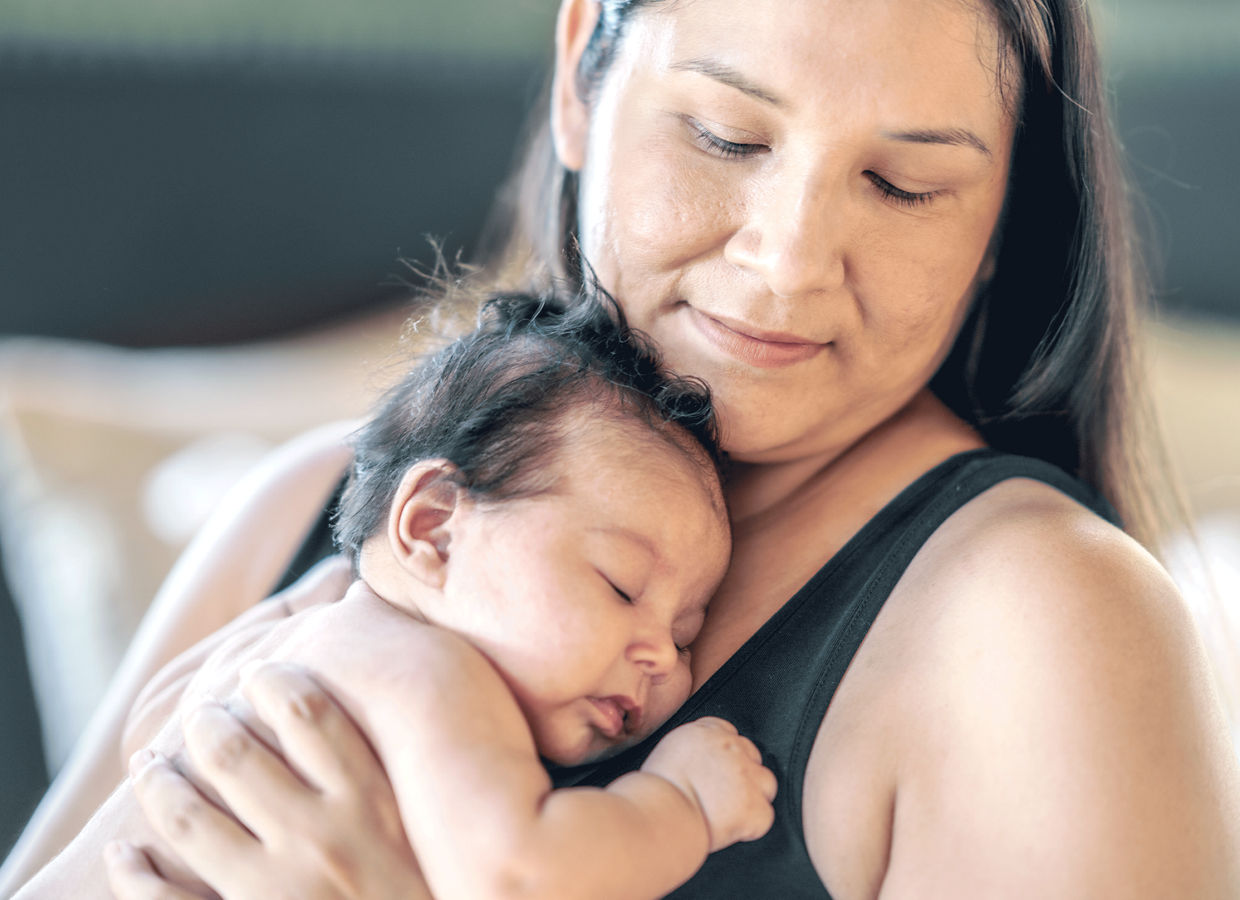 Una madre che tiene in braccio il suo bambino.