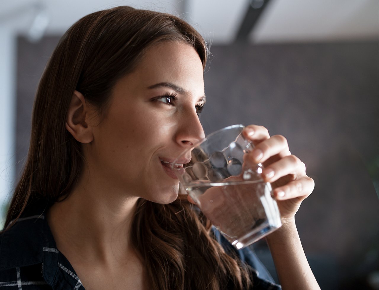Nuori nainen juo vettä lasista