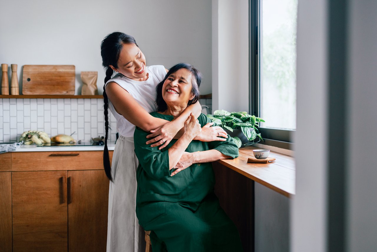 Young girl hugging her mother in the kitchen