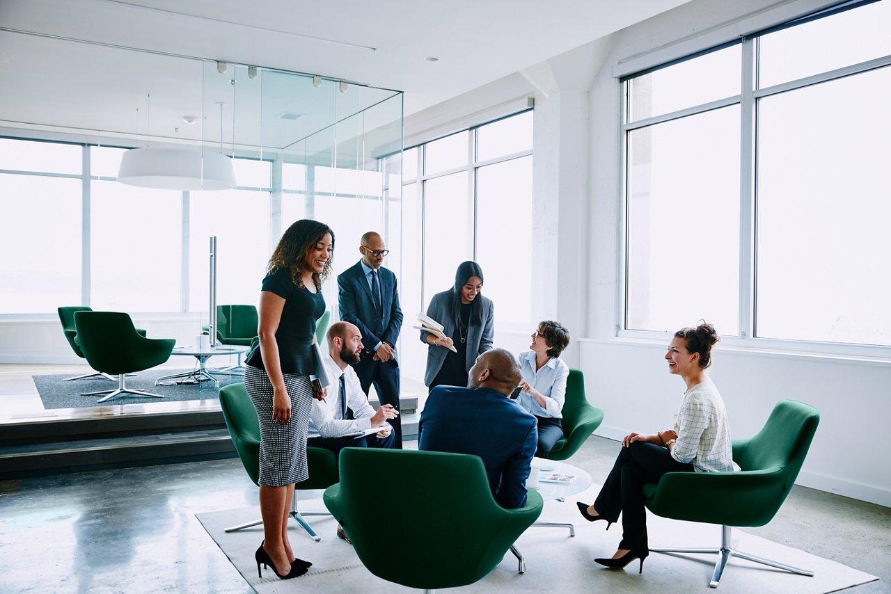 Several business professionals interacting in an open office setting.