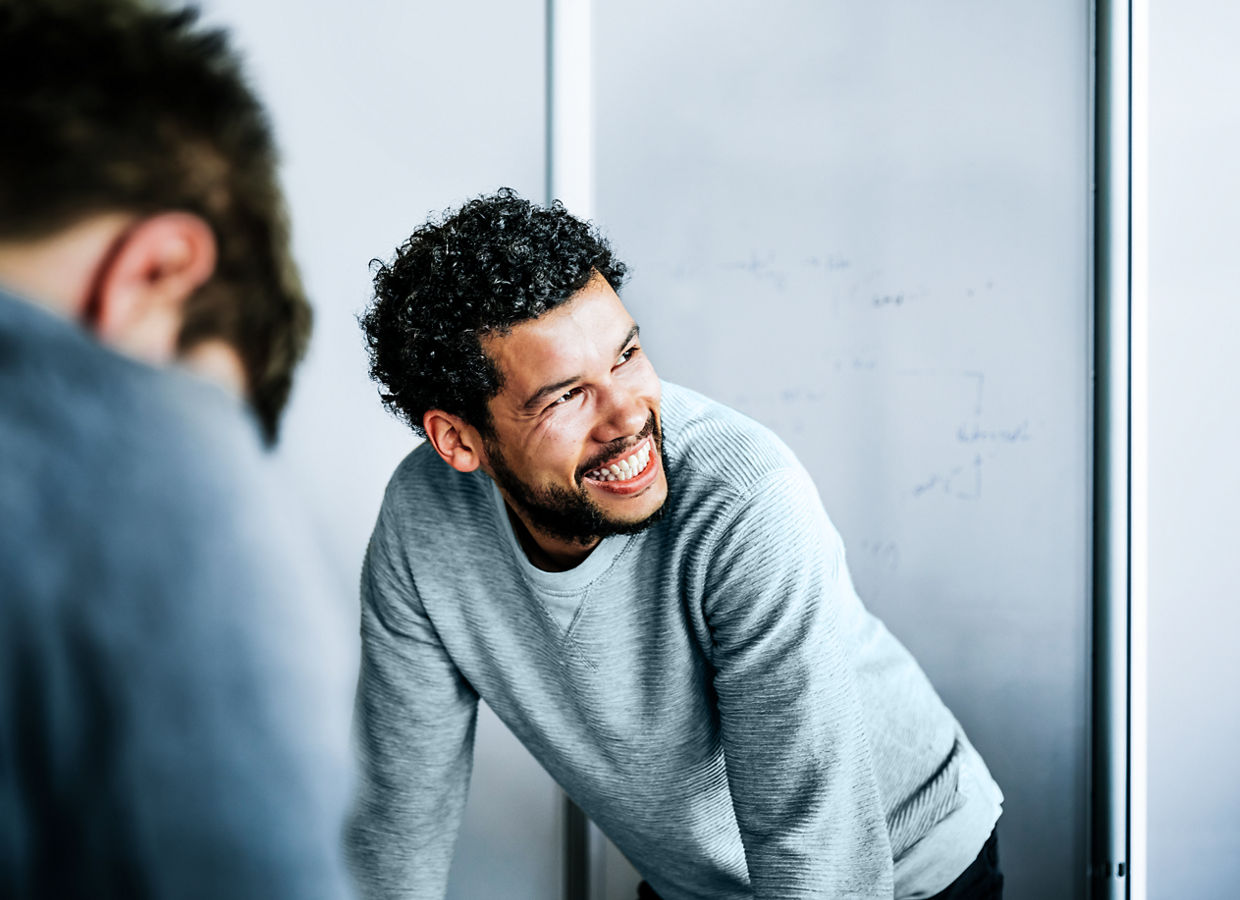 Portrait of a casual afro-american businessman during a  meeting. He's smiling to his colleague