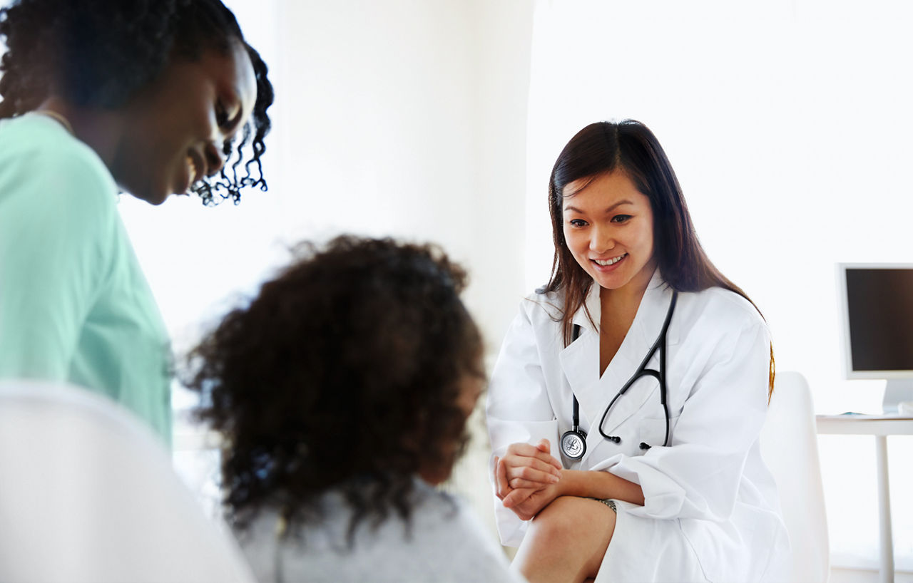 Doctor talking to girl with mother