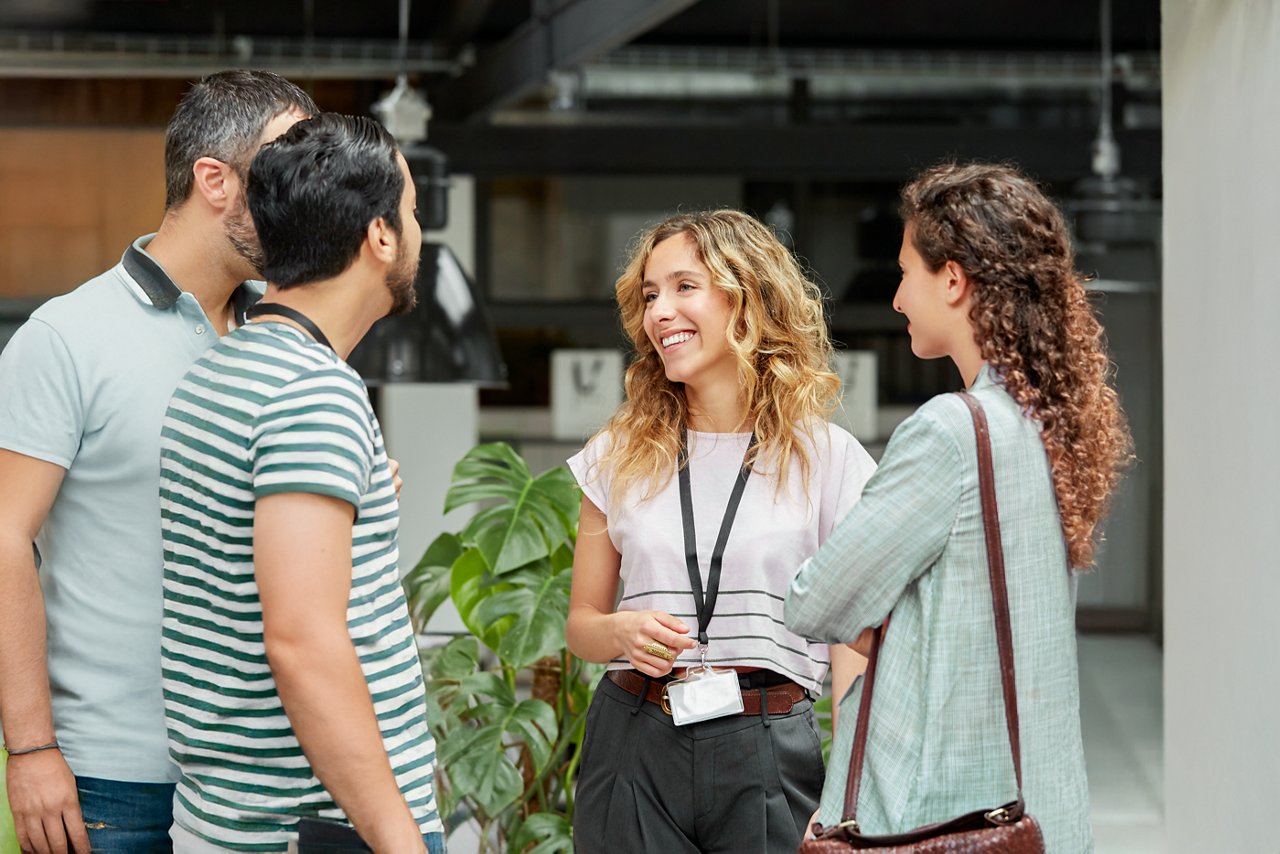 Four colleagues chatting while standing outside.