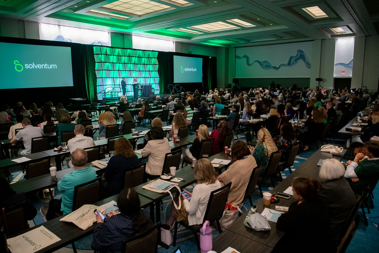 Crowd of attendees seated in front of stage at 2025 Client Experience Summit (CES)