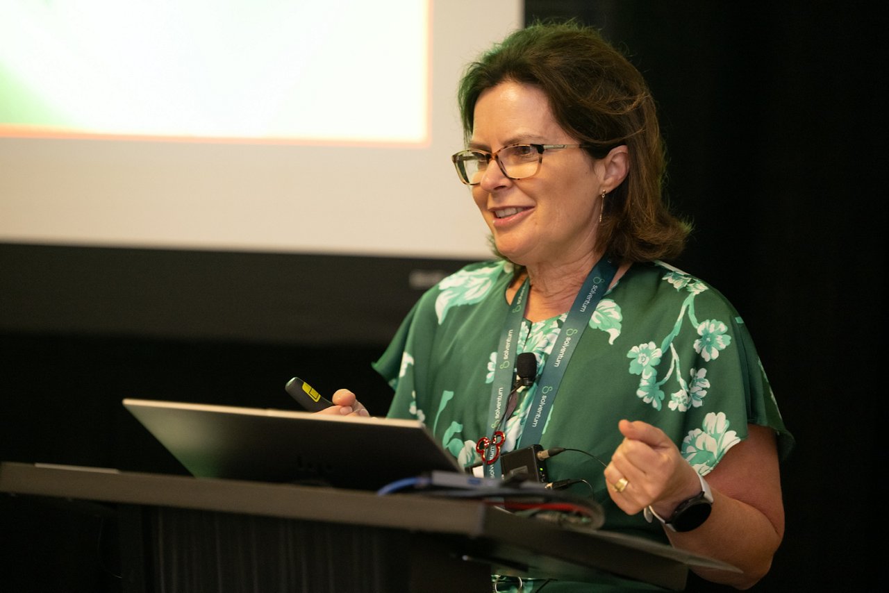 Woman speaking at podium at the 2025 Client Experience Summit (CES)
