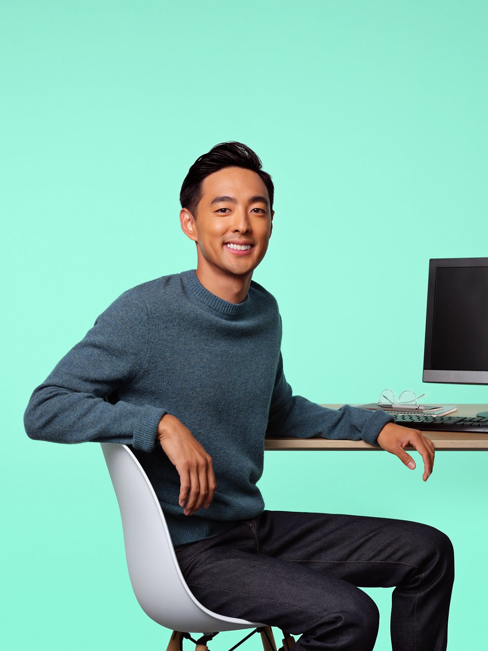 A software engineer seated at a desk in front of a monitor.