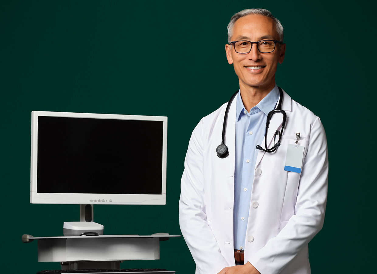 A medical doctor with a stethoscope around their neck standing next to an ambient device.