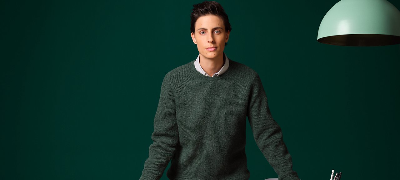 Un homme debout à un bureau moderne avec un ordinateur portable.