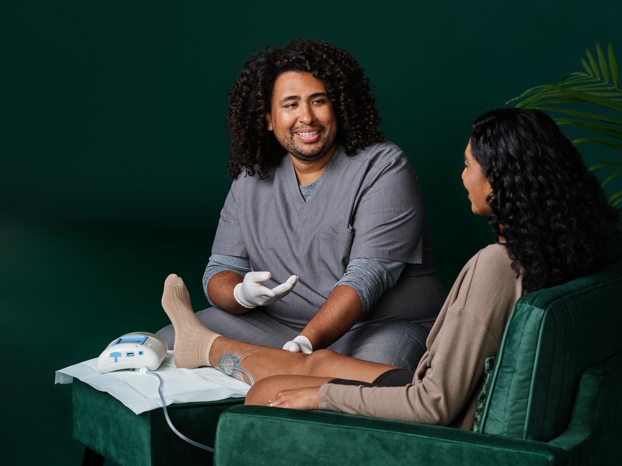In-home nurse interacting with a patient that has a ActiVAC Therapy Unit attached to patient's leg.