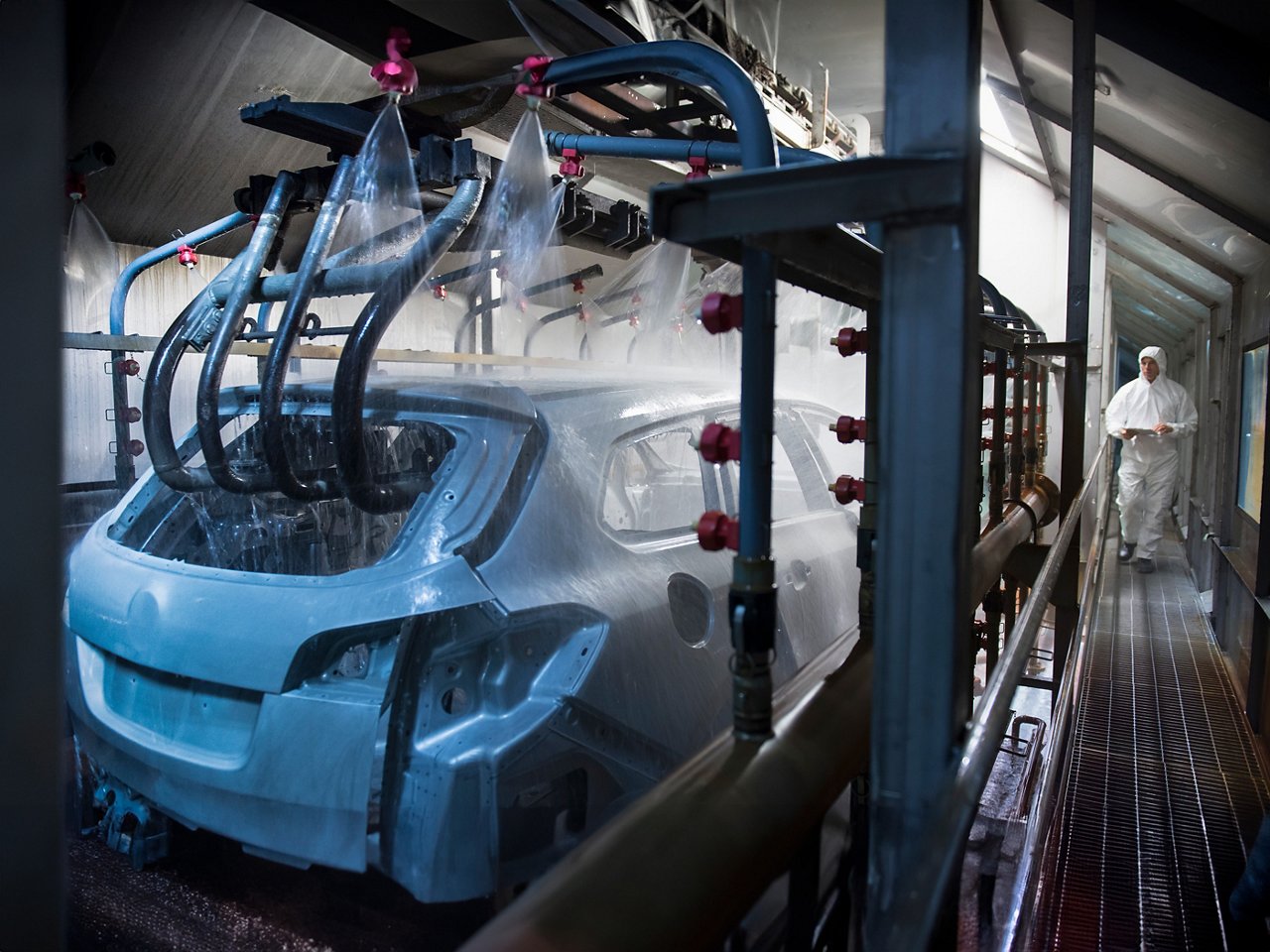 Car bodies being cleaned prior to spraying in car factory