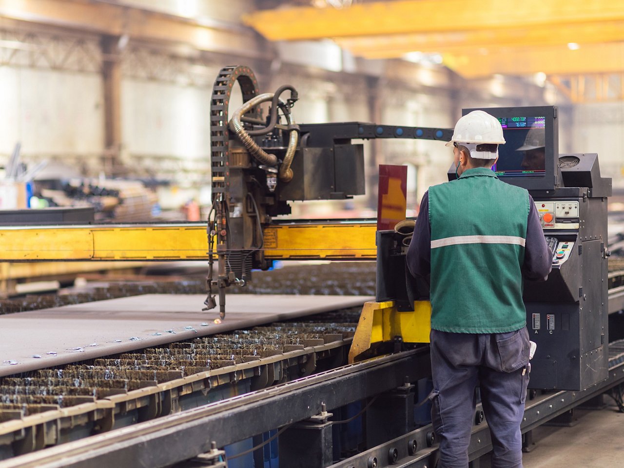 Trabajador de acero en máquina cortadora de plasma CNC
