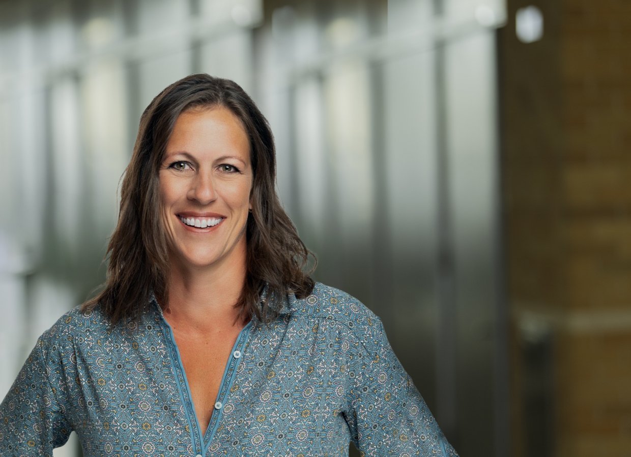 Executive Woman with floral shirt headshot on an office background