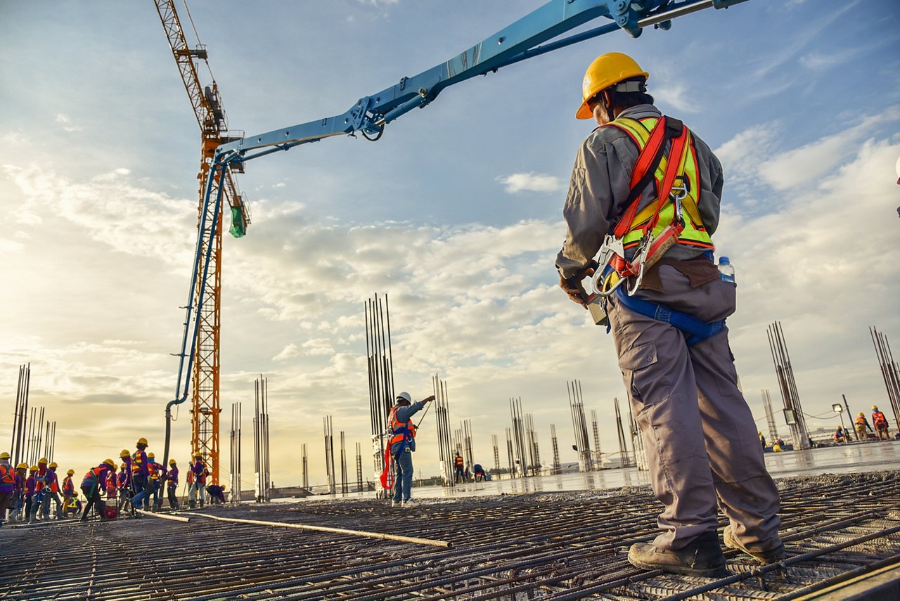 A construction worker control a pouring concrete pump on construction site and sunset background; Shutterstock ID 752076598; Purchase Order/Charge Code: -; Ordered By (email address): -