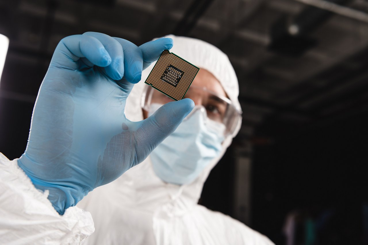 selective focus of microprocessor in hand of scientist wearing latex glove 