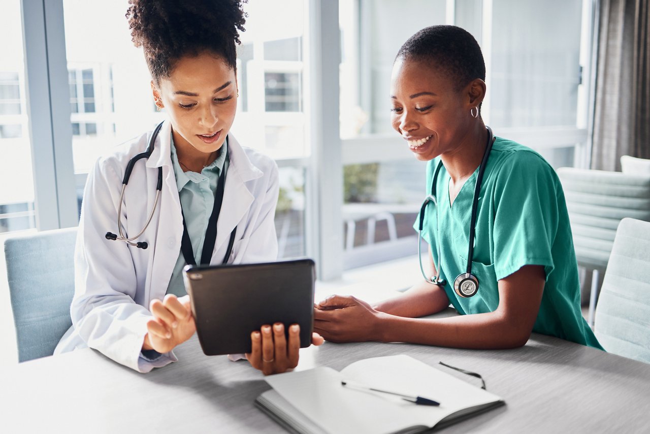 A nurse and a clinician looking at a tablet both wearing classic iii littmann stethoscopes