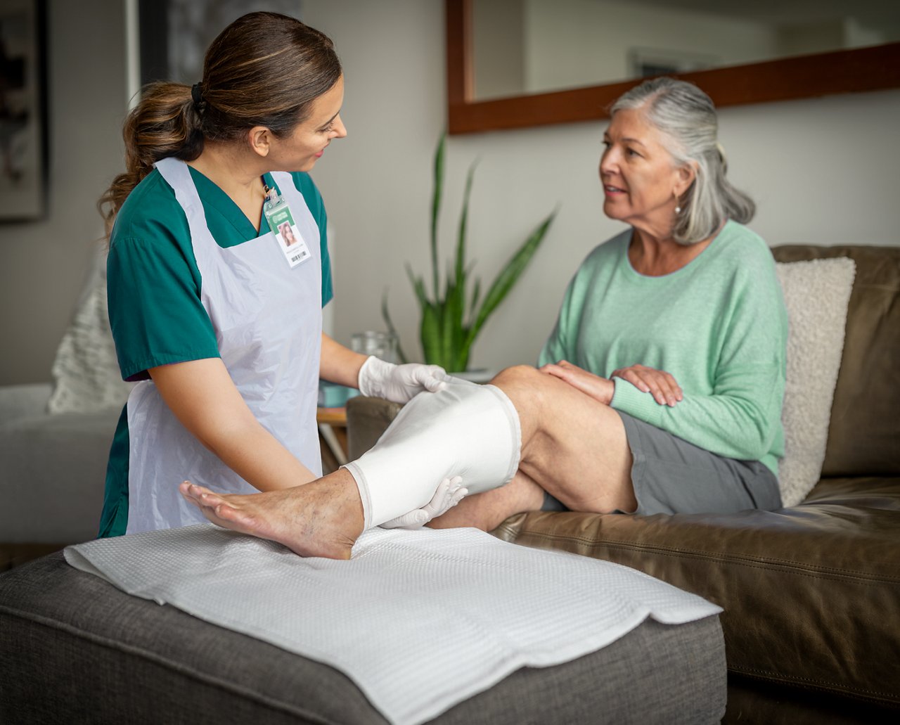 Female patient with VLU being treated 3M™ Kerramax Care™ Super-Absorbent Dressings in home care by clinician., rgb, tif