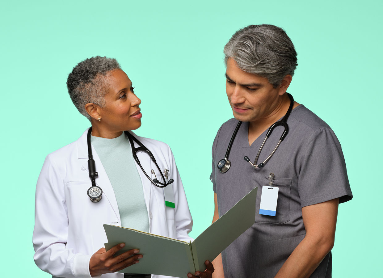 A medical doctor and nurse discussing a patient chart.