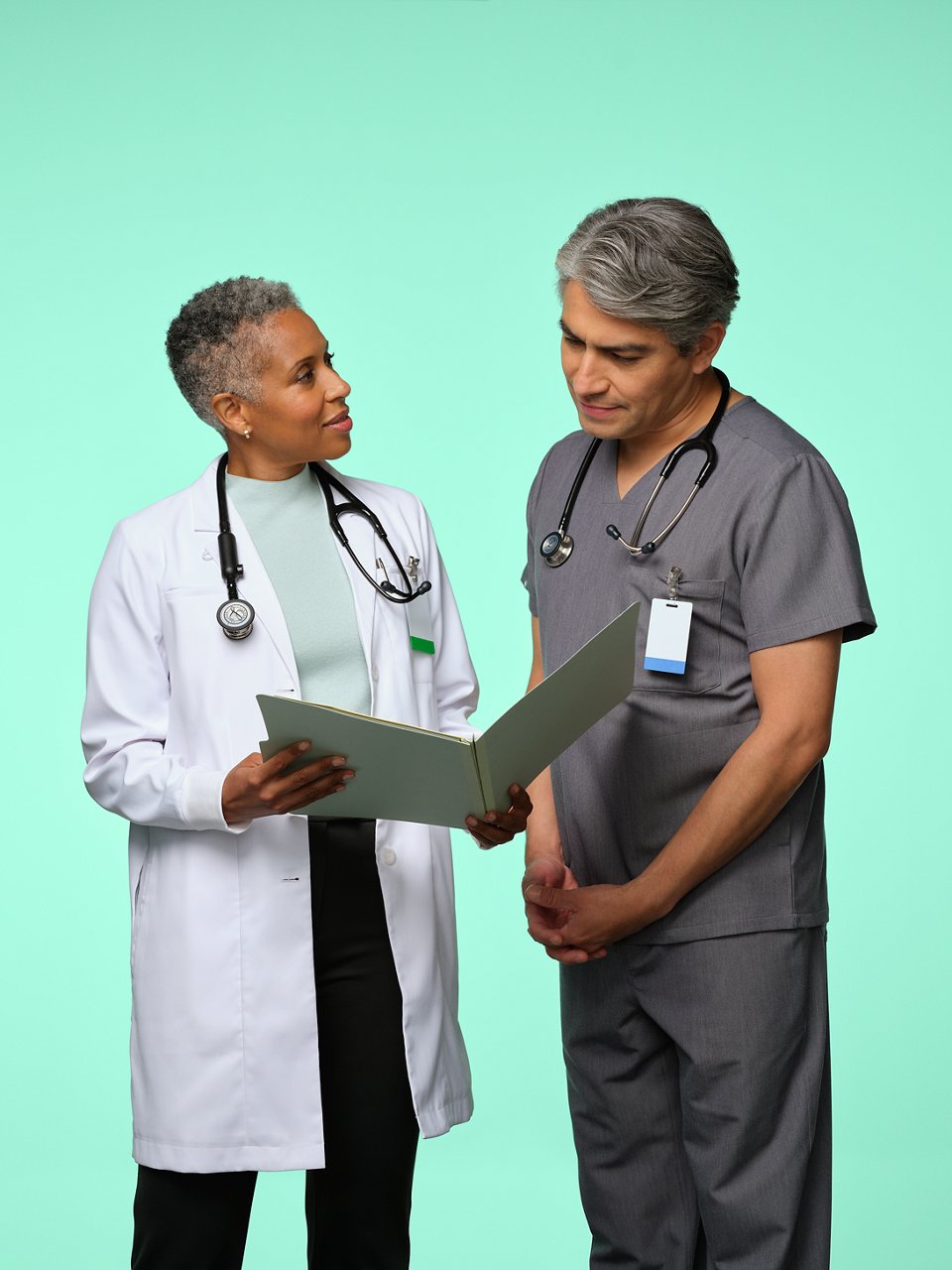 Un médico y una enfermera discutiendo una ficha de paciente.