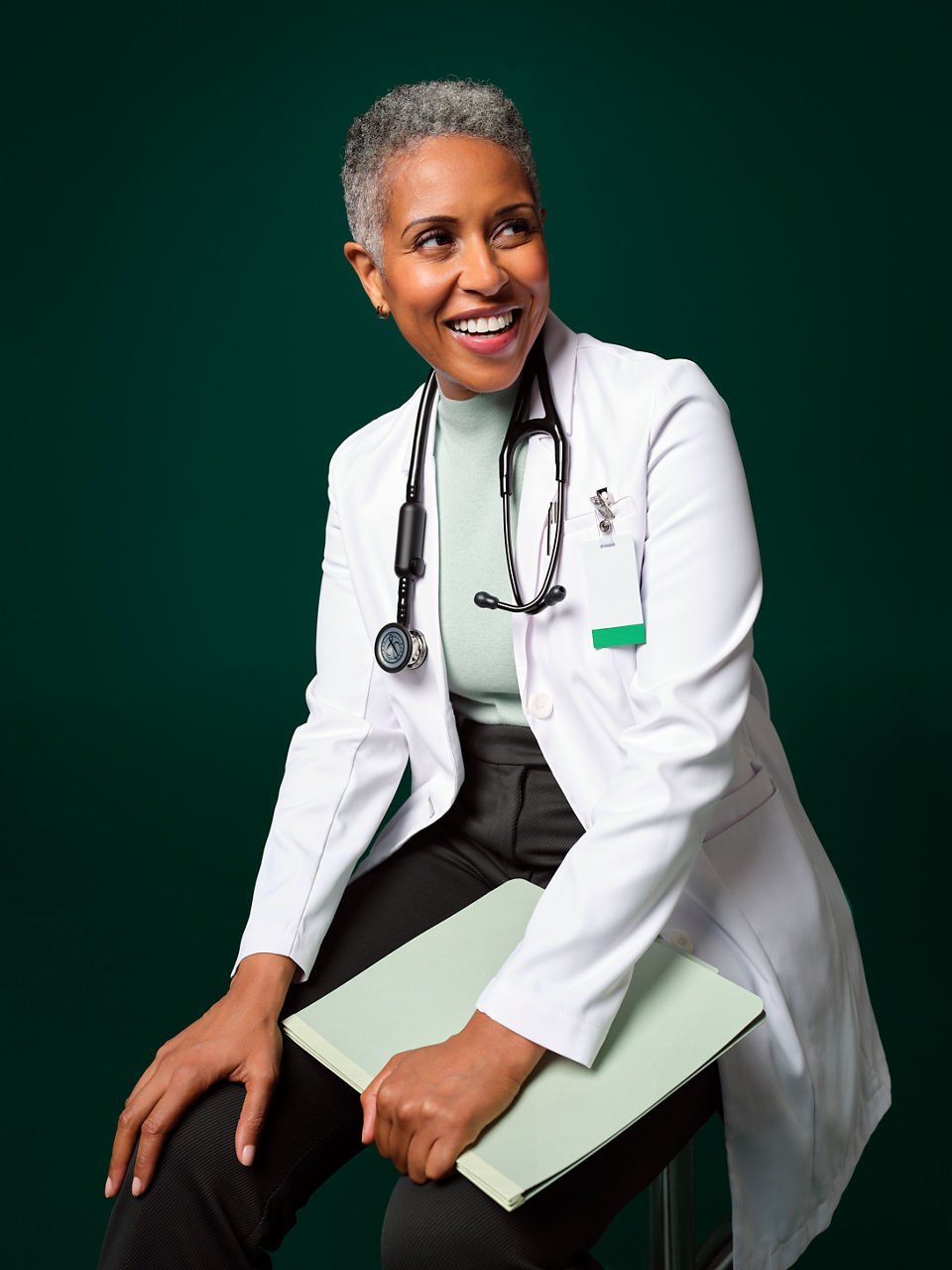 Doctor sitting on a stool.
