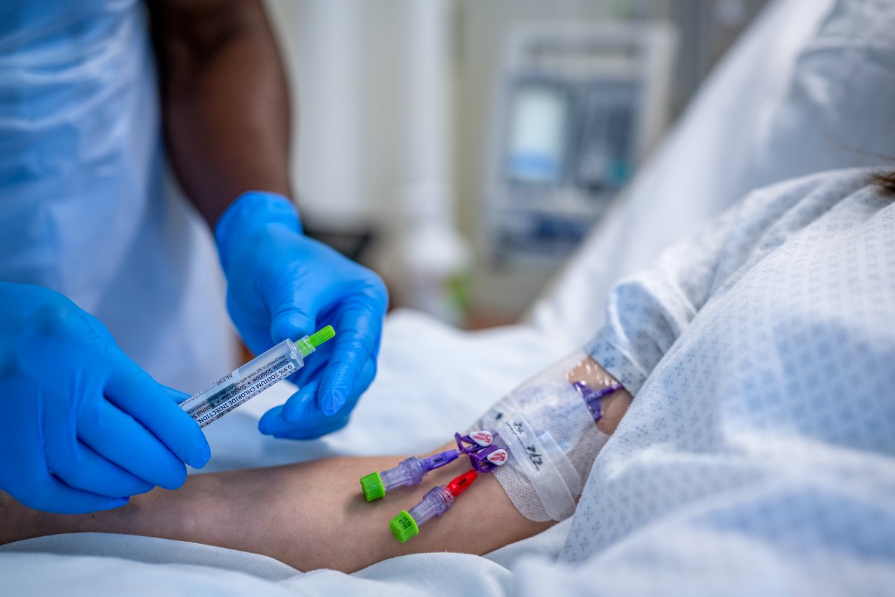 Curos-Kappen für den Kliniker, der eine Linie mit Curos-Tipps™ mit einem Patienten mit einer PICC-Linie mit einer Kappe von