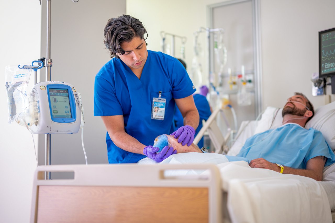 Patient in hospital with nursing staff preparing for and applying VAC therapy for amputation case; photo 3