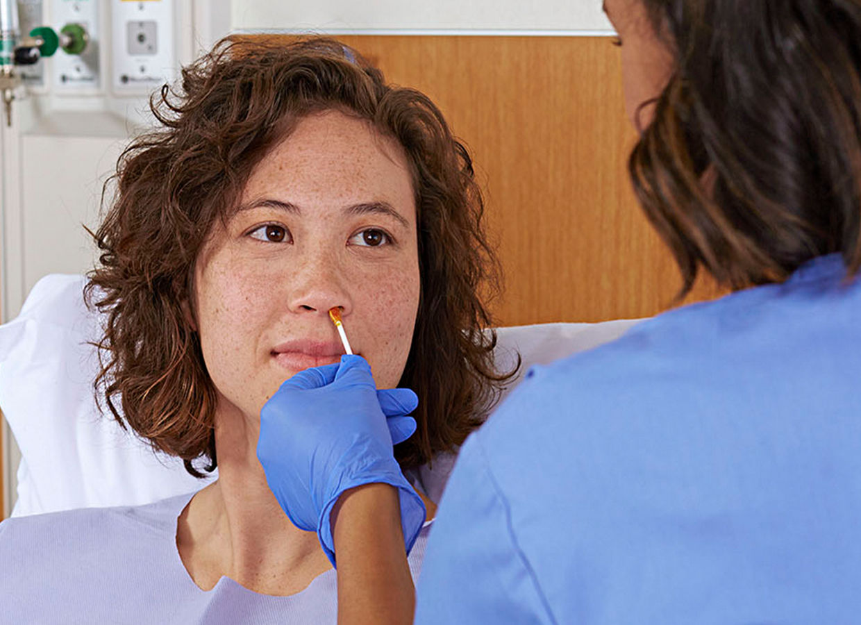 Nurse swabbing female patient's nose. Skin and nasal image. 