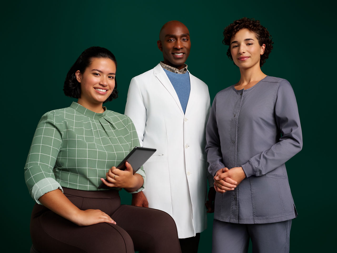 Group portrait of a team of three orthodontic professionals on a dark green background.