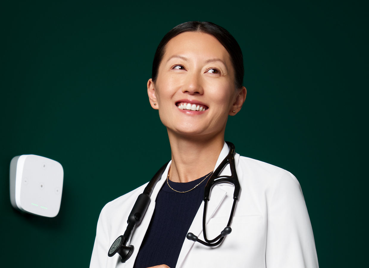 Médico de atención primaria sonriente con bata blanca.