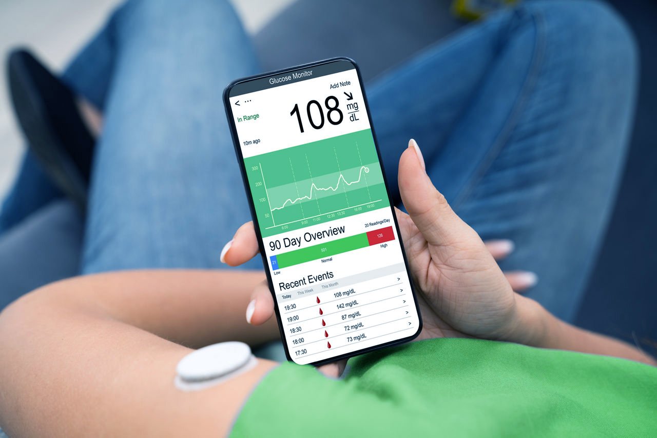Uma foto de uma mulher monitorando suas informações de saúde em um smartphone.