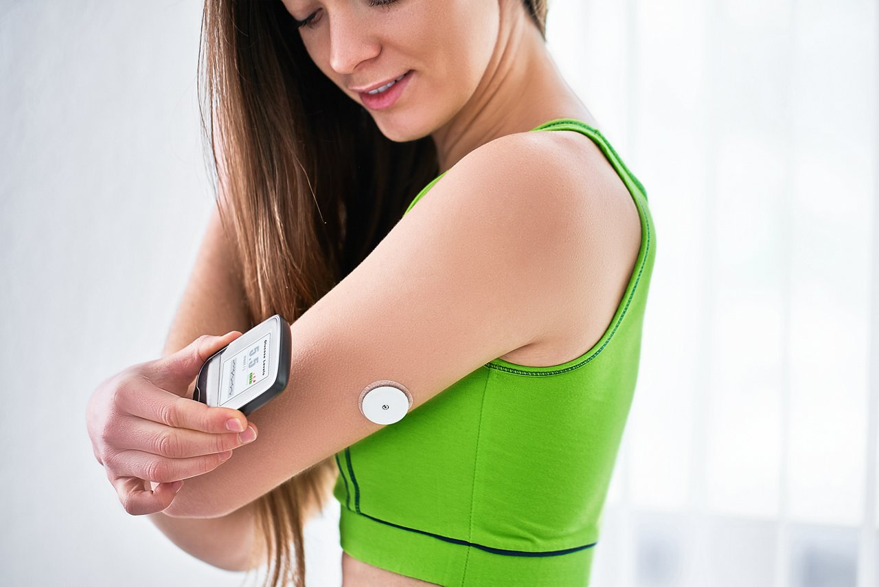 Female athlete checking her wearable monitoring device.