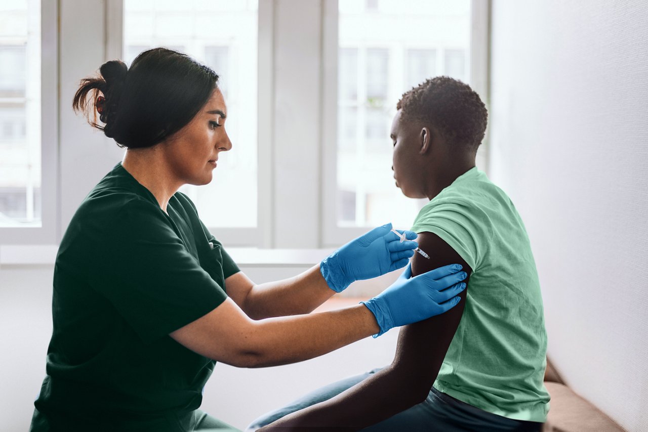 Female nurse preparing to give a vaccine to a male patient in a doctor office