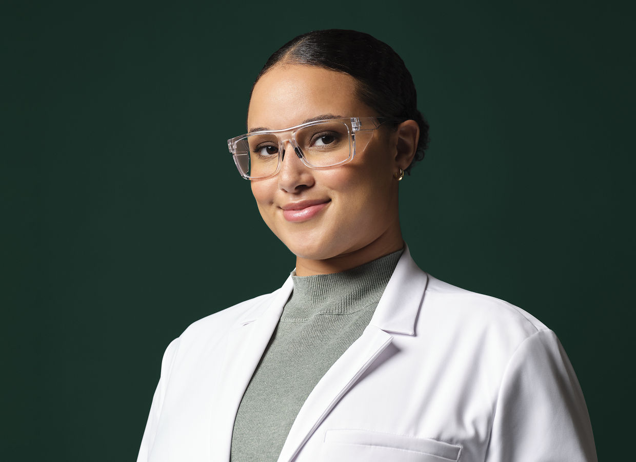 Female application engineer wearing white lab coat, safety googles and blue gloves