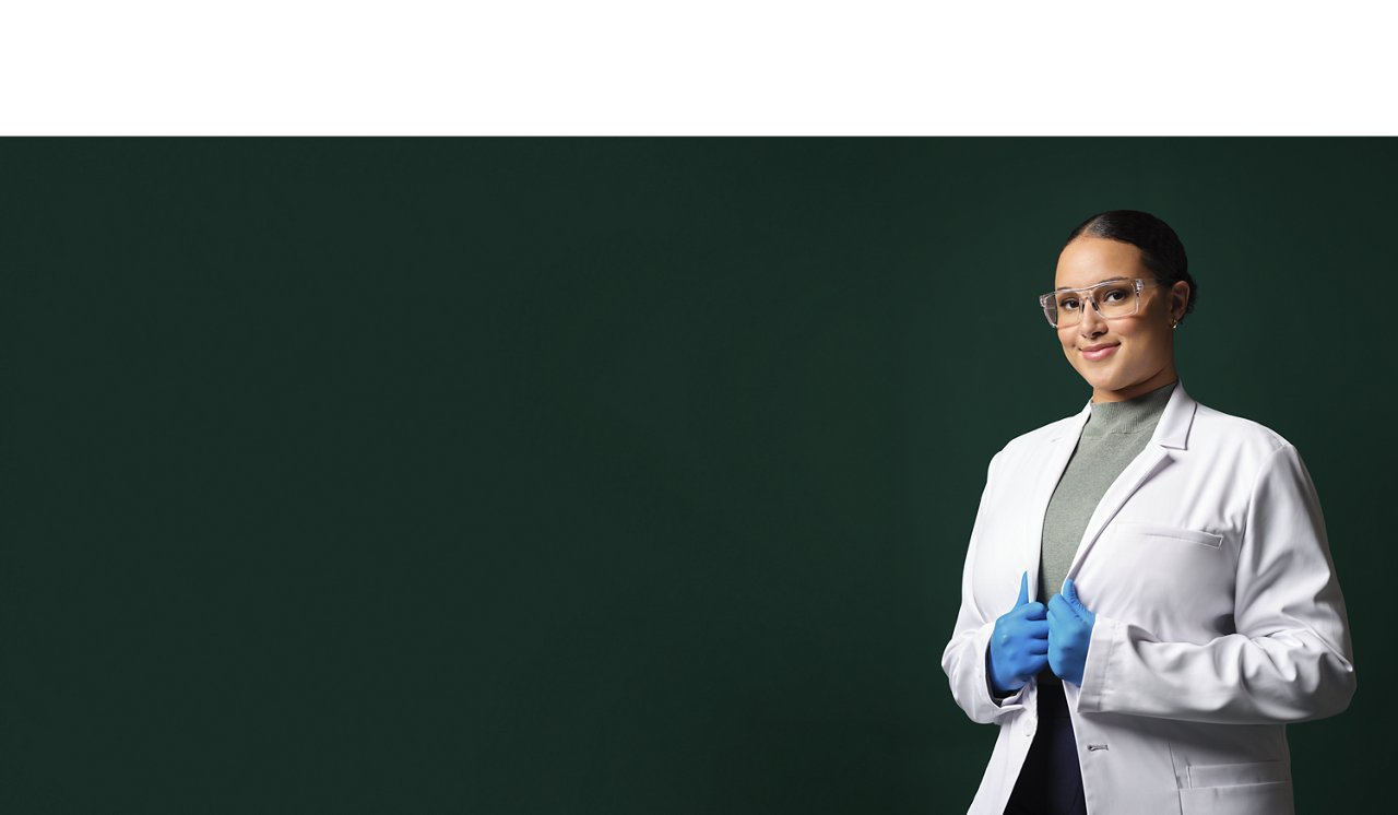 An application engineer wearing a white lab coat, safety googles and blue gloves