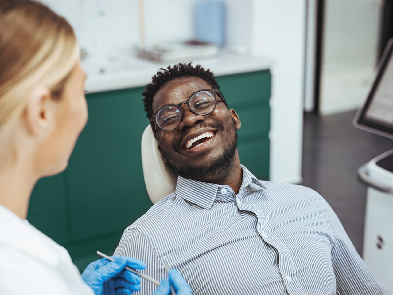 An image of a man smiling while looking at his dentist