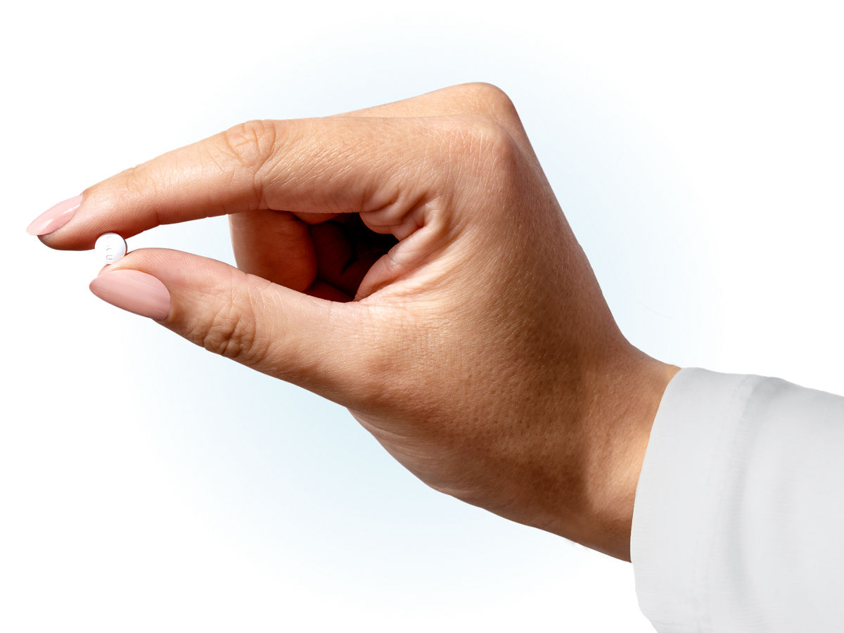 Hand holding a Wegovy<sup>®</sup> pill