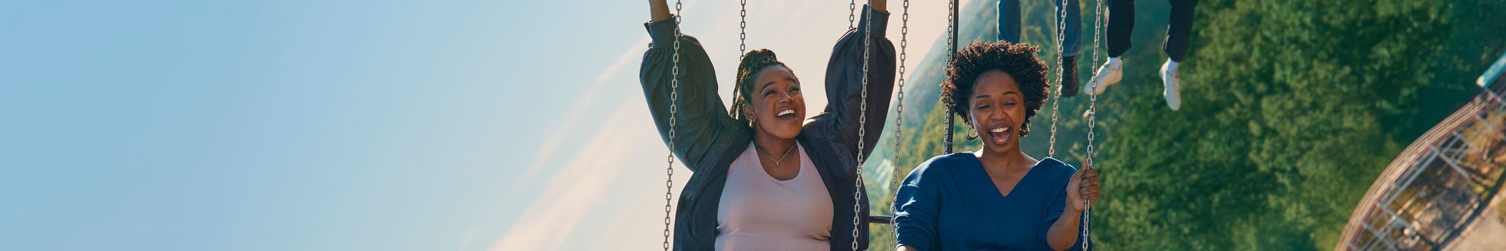Two women laughing on a swing ride at the fair