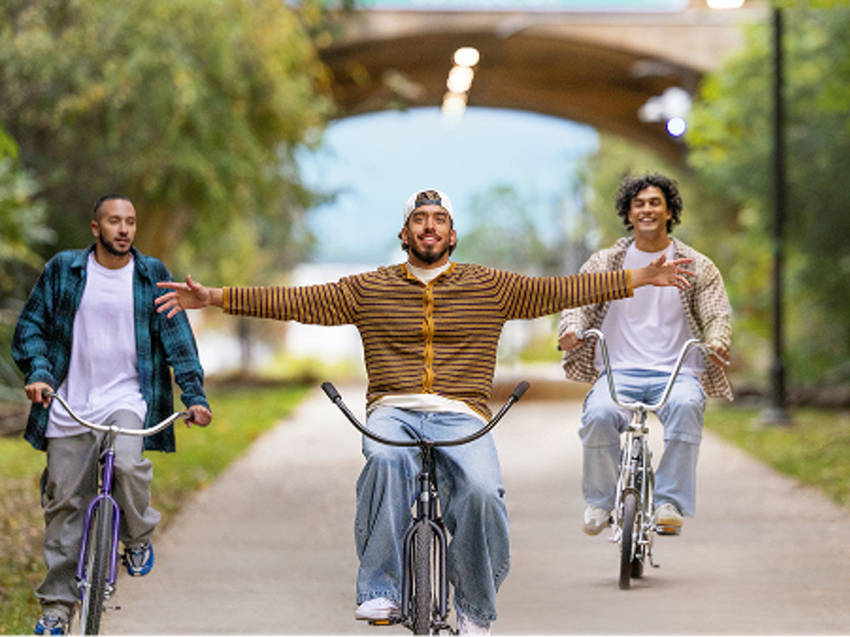 Man riding his bike hands-free through the park
