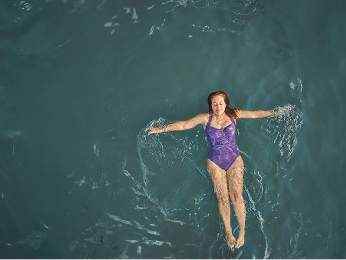 Woman taking a leisurely swim in the lake 