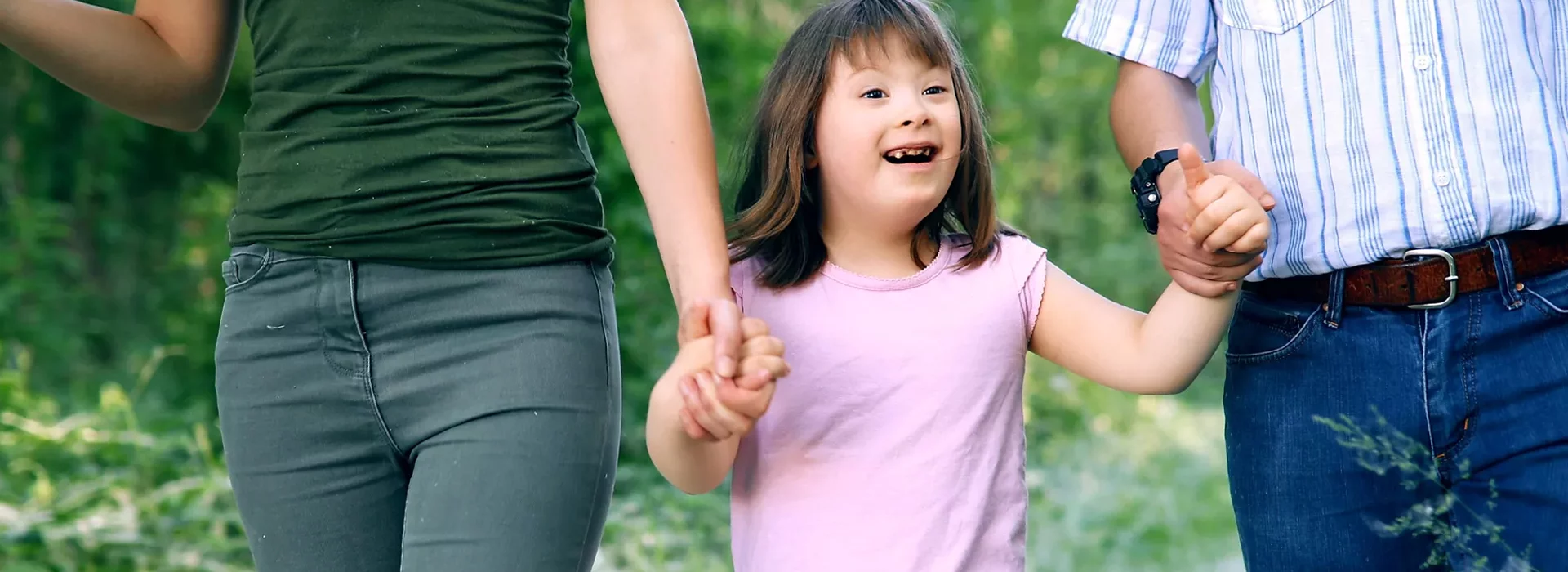 Girl holding hands with parents