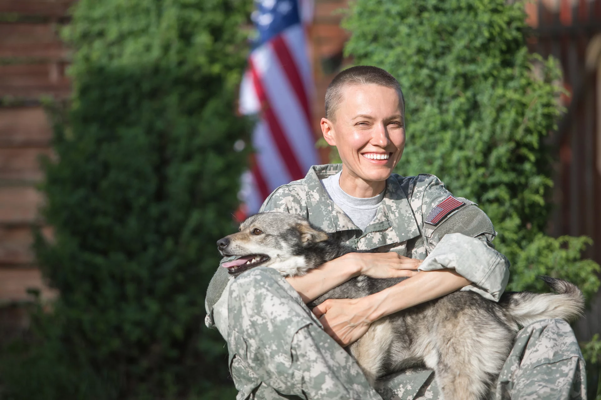 Lady in military clothing petting a dog