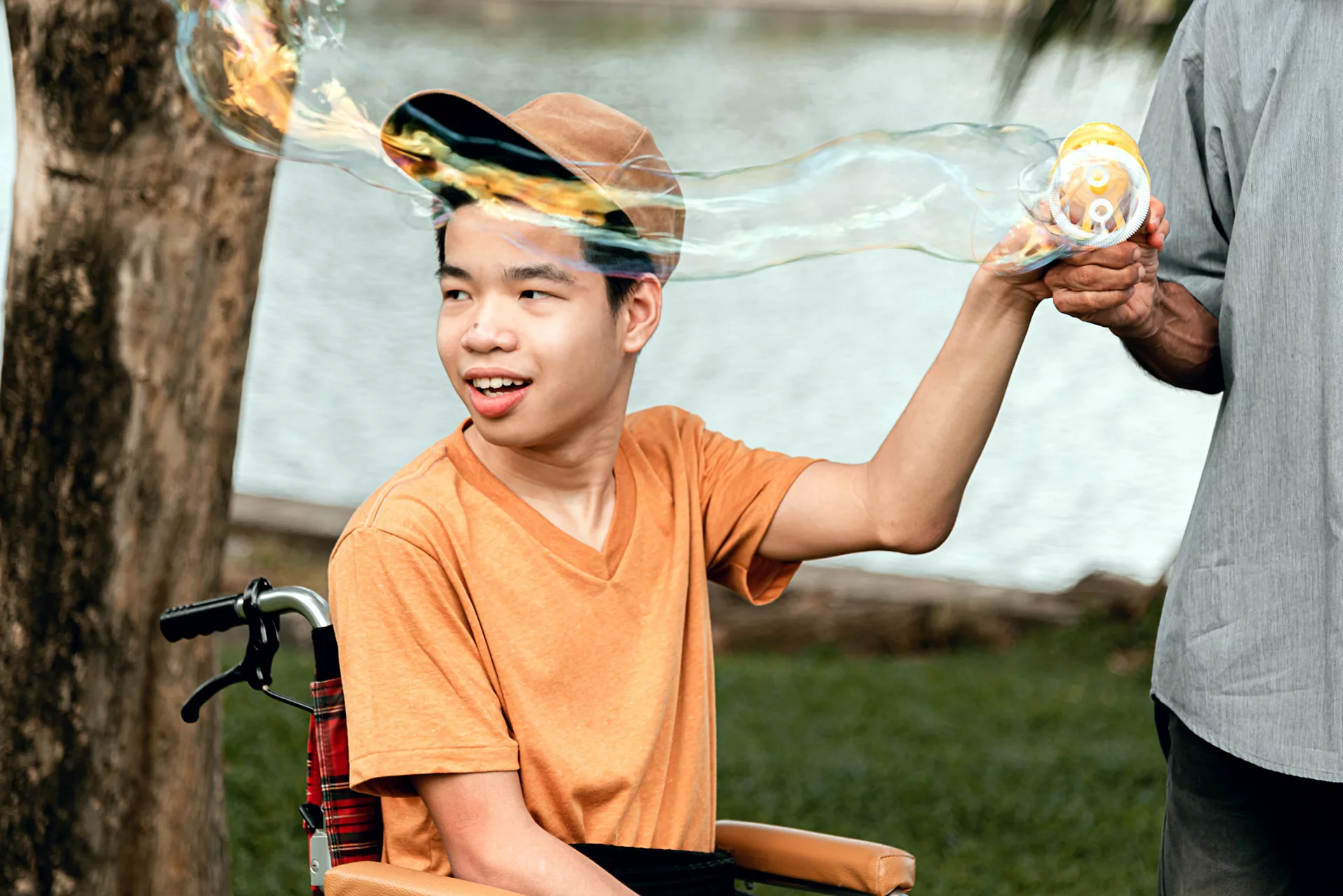 Disabled child on wheelchair smiling face as happy with parent in the nature outdoors park, Lifestyle in the education age of special need kid, Happy disability teen and diverse people concept.