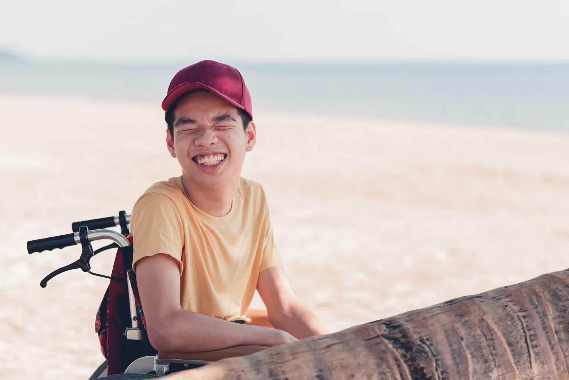 Young man with disability with happy face on the sea beach in vacation holiday, Nature therapy for good mental health and strong body through outdoor activities.