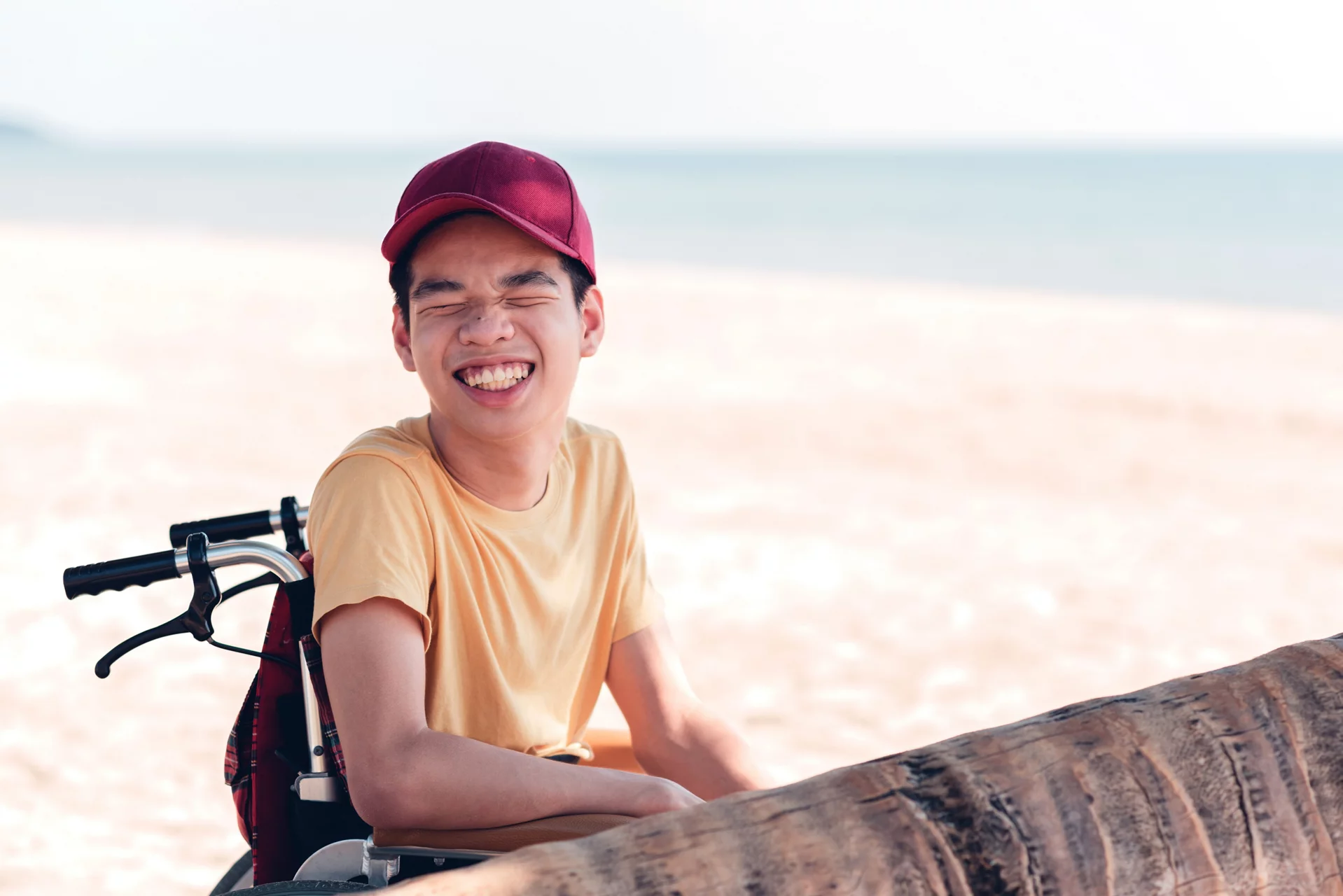Young man with disability with happy face on the sea beach in vacation holiday, Nature therapy for good mental health and strong body through outdoor activities.