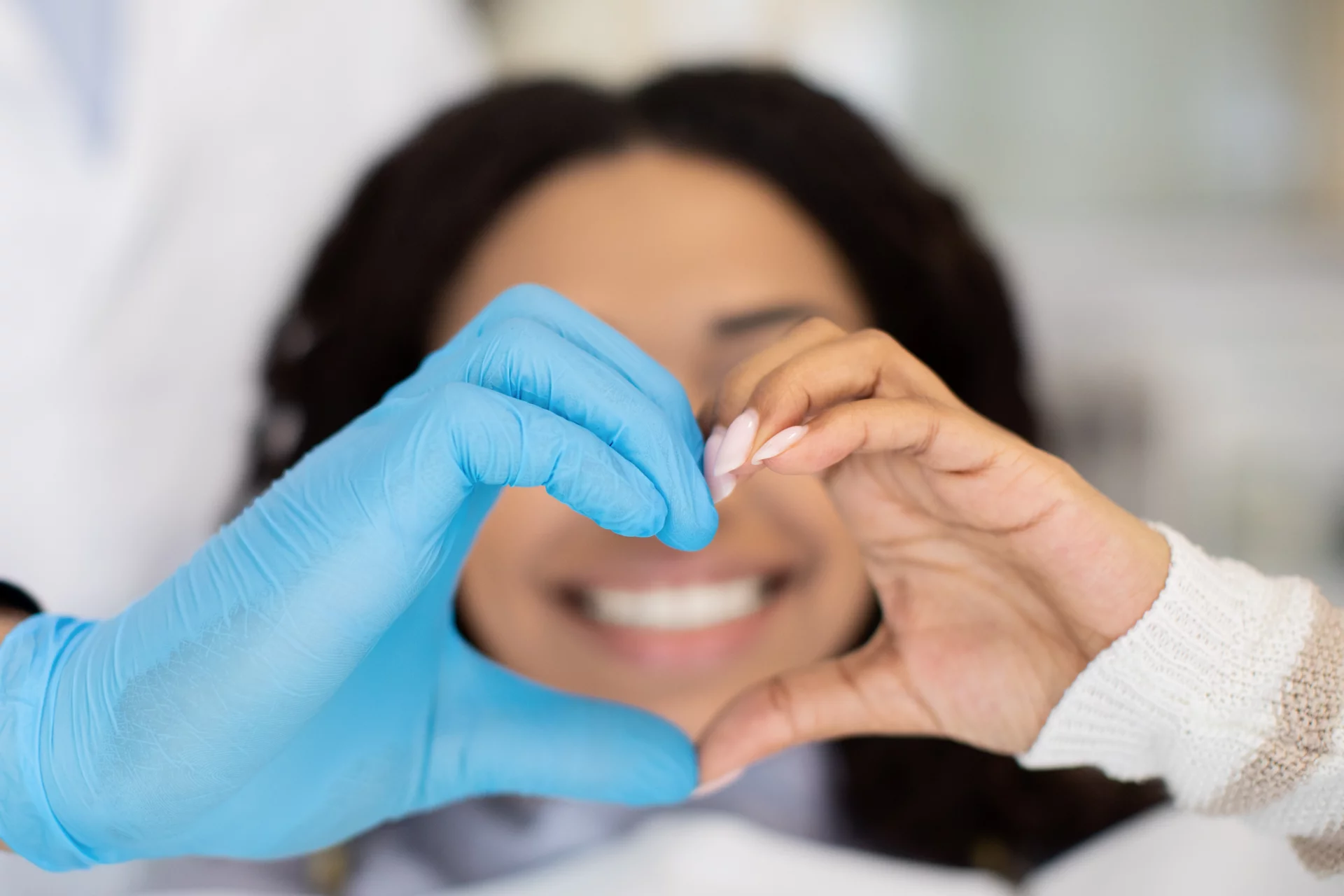 Closeup Shot Of Dentist Doctor And Female Patient Making Heart Gesture With Hands, Professional Stomatologist Wearing Blue Medical Glove, Black Lady Happy With Successful Teeth Treatment, Cropped