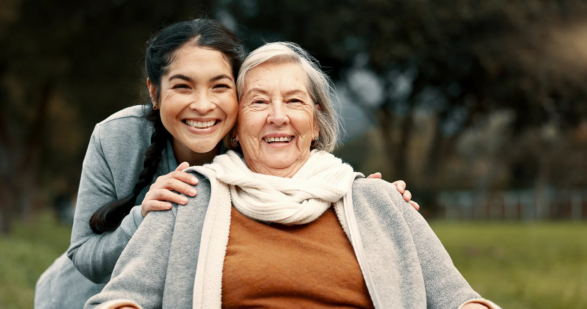 Portrait, senior woman and outdoor with caregiver, nurse or healthcare service for person with a disability and wheelchair. Happy, face and elderly lady in park with care and support in retirement.