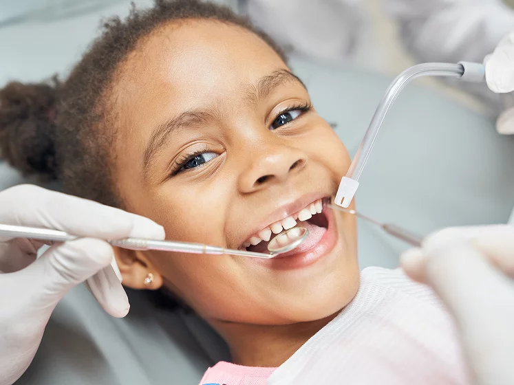 Girl smiling getting her teeth checked by dentist
