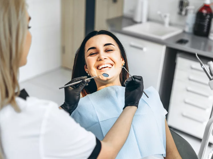 Lady smiling getting her teeth checked by dentist