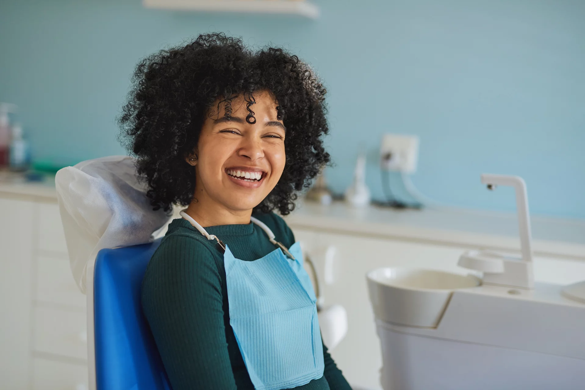 Shot of a happy young woman sitting in a dentist’s chair