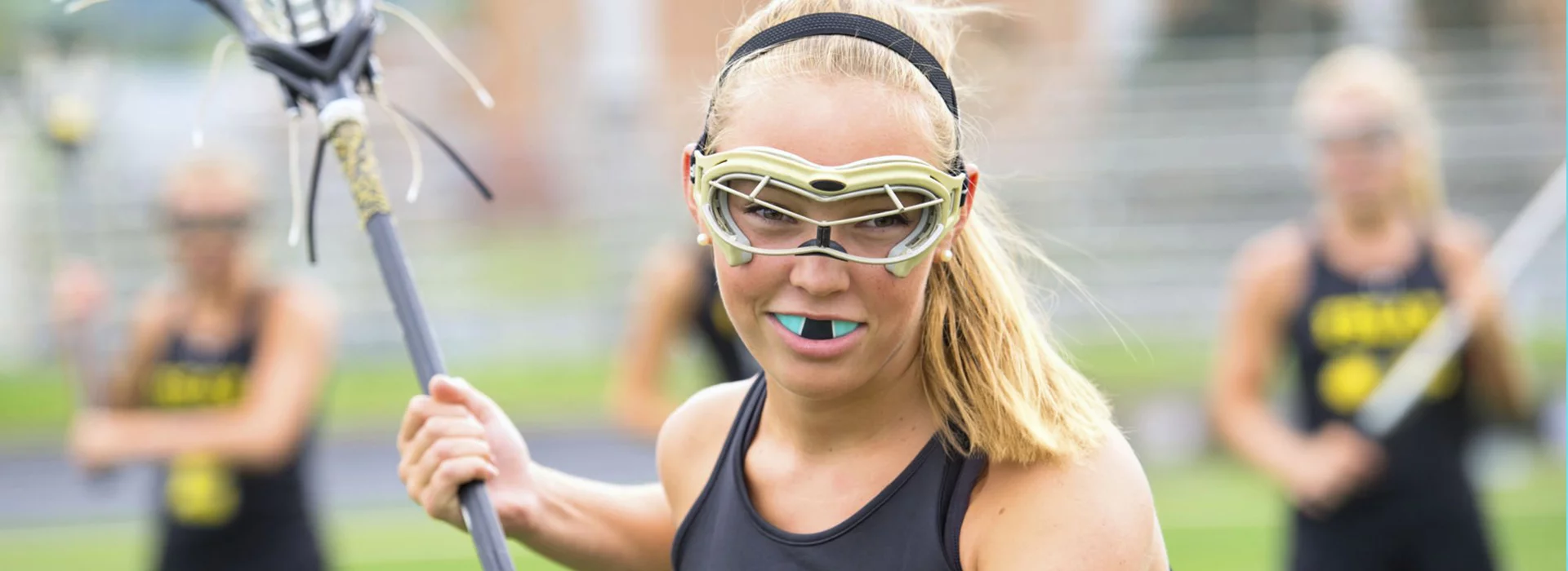 Girls play lacrosse with mouth guard