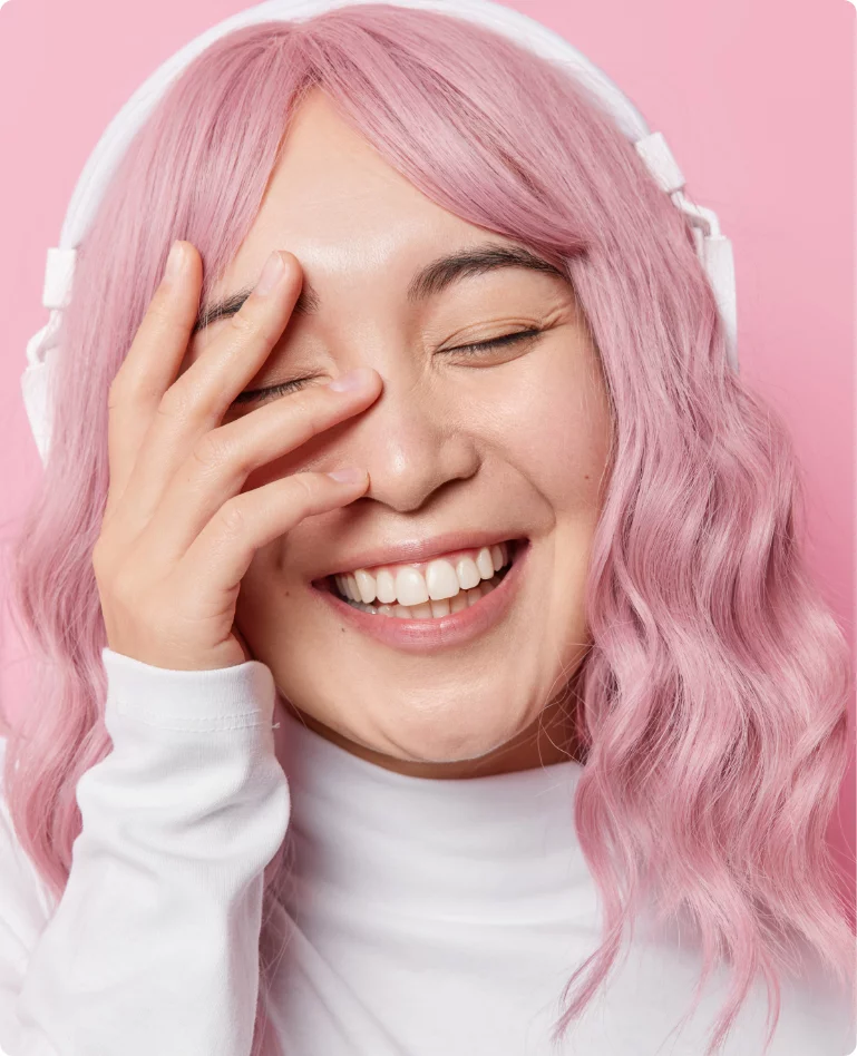 Individual smiling with a pink background